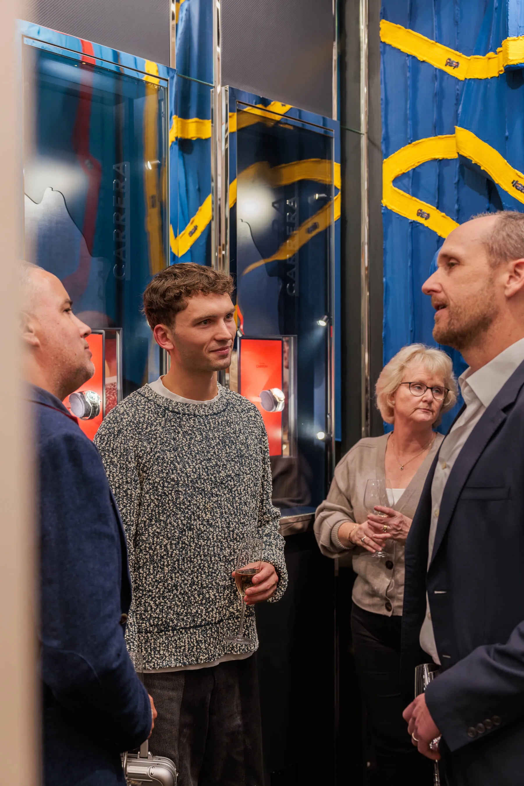 Werner Bronkhorst chats with guests against a backdrop of his artwork and TAG Heuer Carrera watch displays during the exhibition | EDG Studios