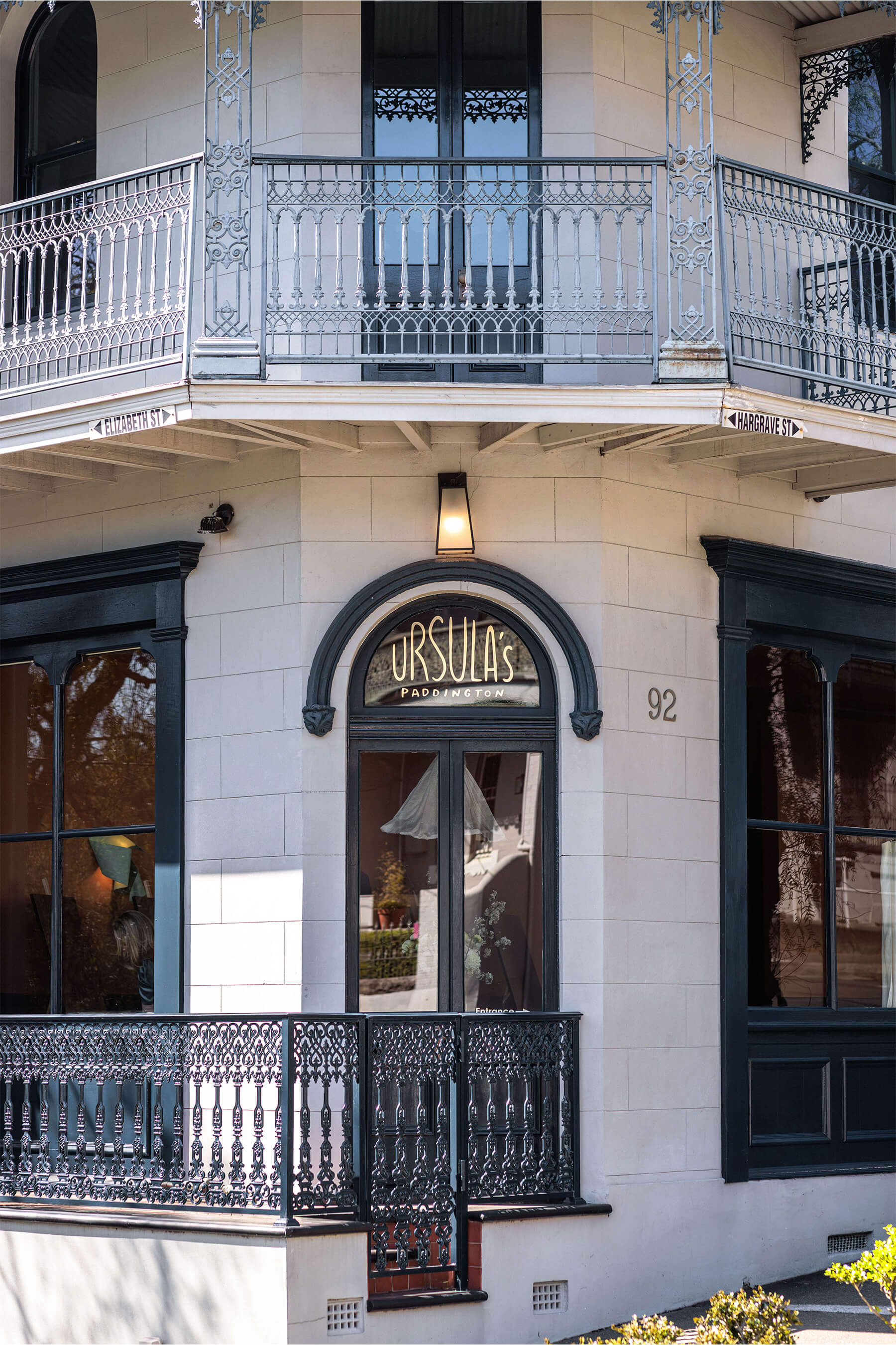 Exterior facade of Ursula’s Paddington with heritage ironwork balcony and the venue name displayed on a curved arched window above the entrance.