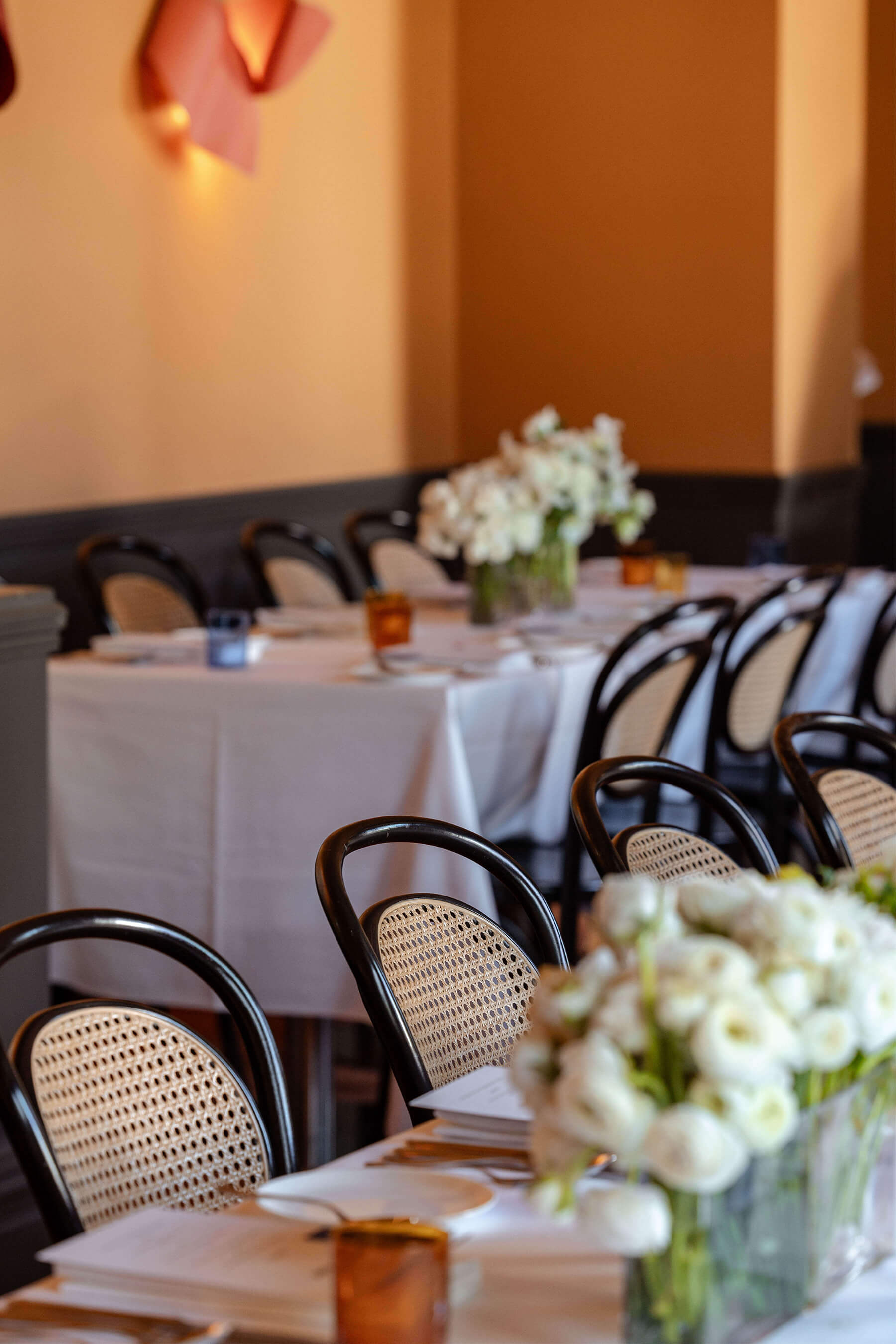 Elegant dining tables set with white tablecloths, amber glassware, and white floral arrangements at Ursula’s Paddington for the Royal Oak Floors launch event.