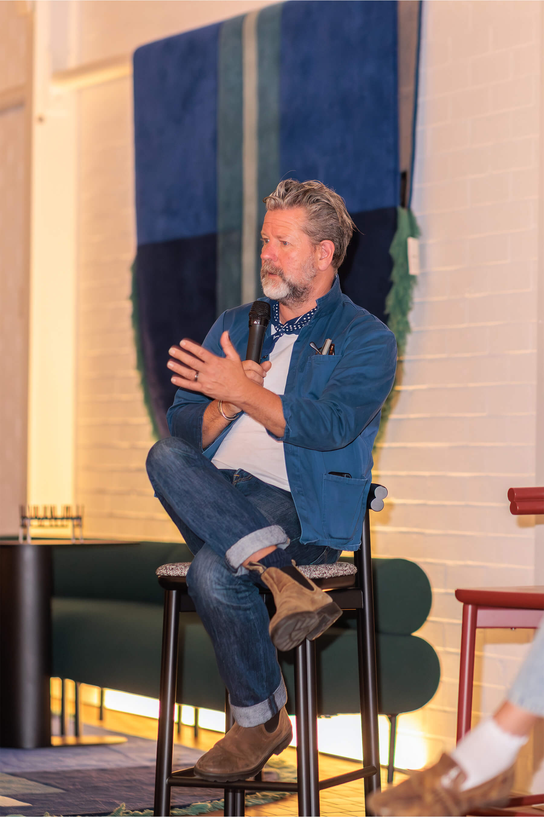 Tim Ross shares insight during the speaker panel at DesignByThem’s “I’ll Be Happy When” event, seated on a DBT studio stool.
