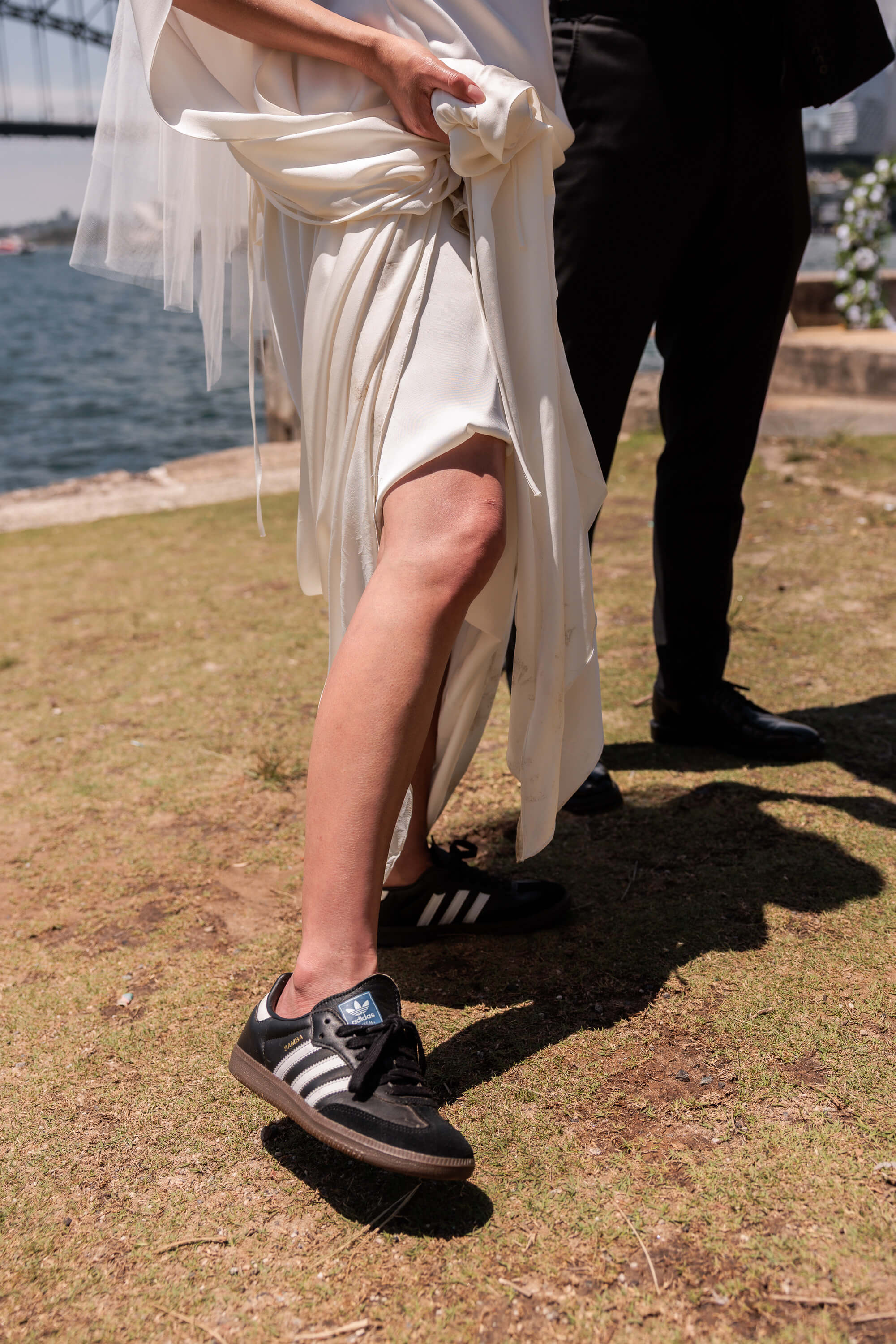 A close detail of Melanie lifting her wedding dress, revealing her shoes, captured during the post ceremony portraits.