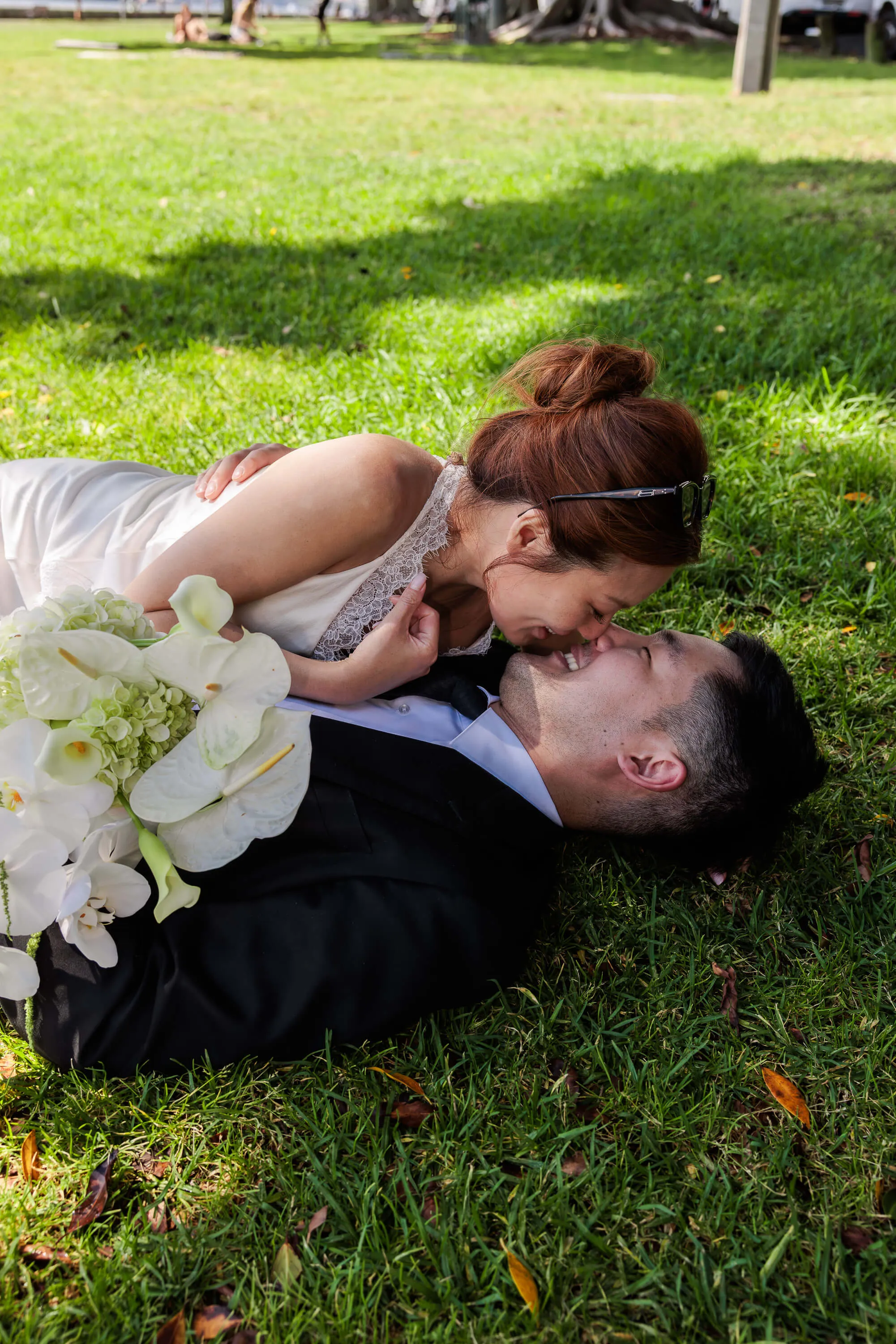 Melanie and Dai smiling and laughing together on the grass after their wedding