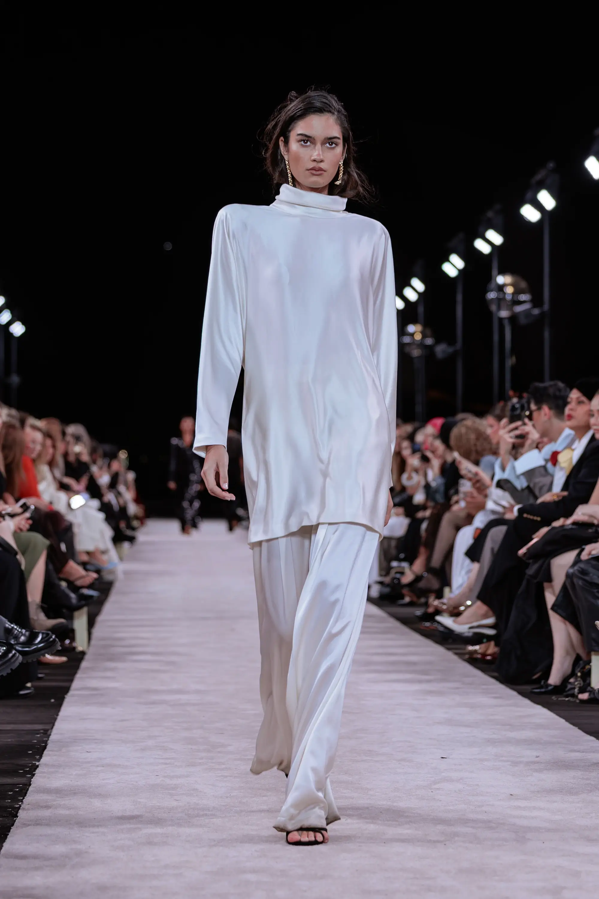 Carla Zampatti ‘Reflections’ runway show photographed at Australian Fashion Week 2026 at the Park Hyatt Sydney Boardwalk, featuring elevated tailoring, fluid silhouettes, shimmering eveningwear and contemporary Australian luxury fashion captured in an editorial runway setting.