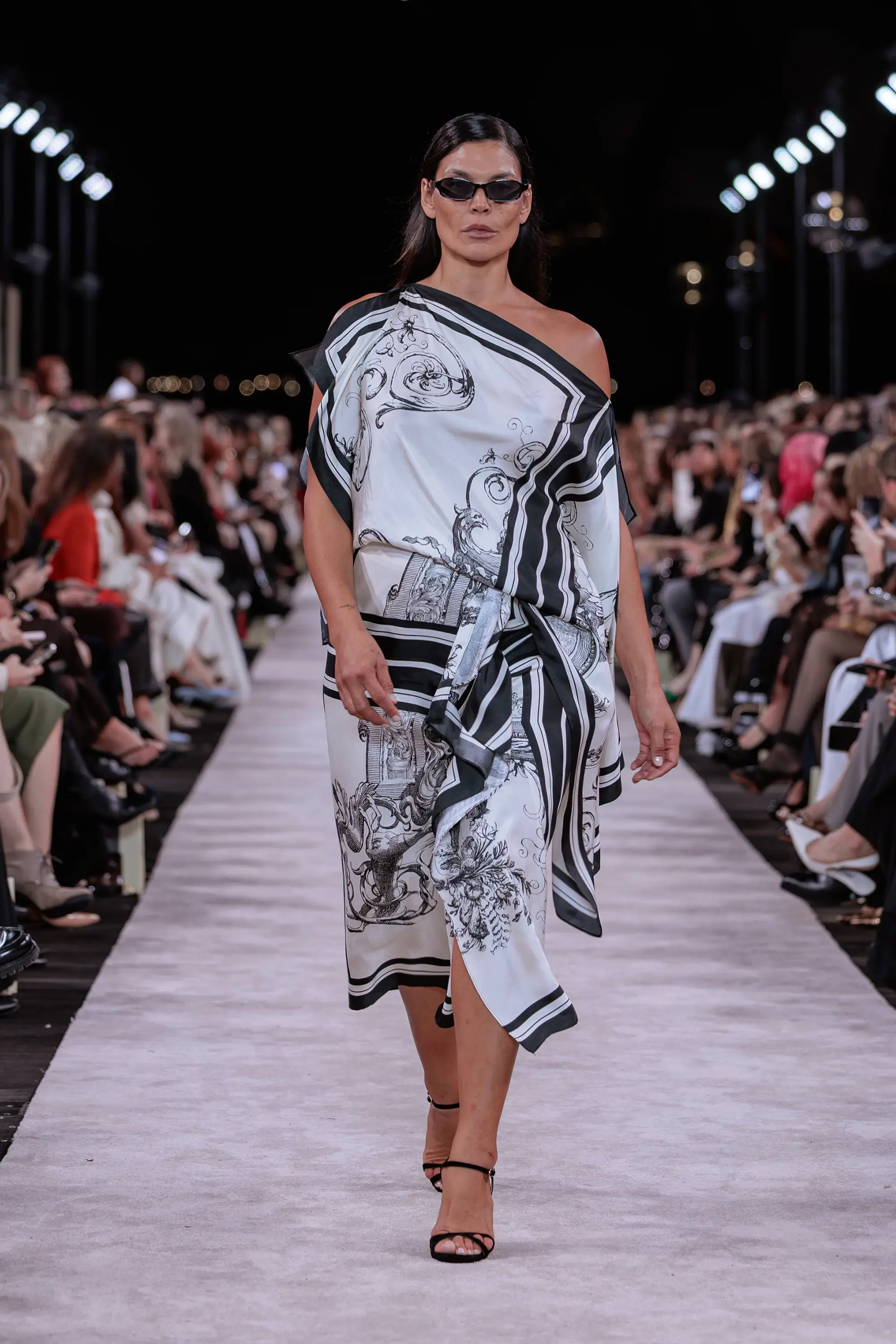 Carla Zampatti ‘Reflections’ runway show photographed at Australian Fashion Week 2026 at the Park Hyatt Sydney Boardwalk, featuring elevated tailoring, fluid silhouettes, shimmering eveningwear and contemporary Australian luxury fashion captured in an editorial runway setting.