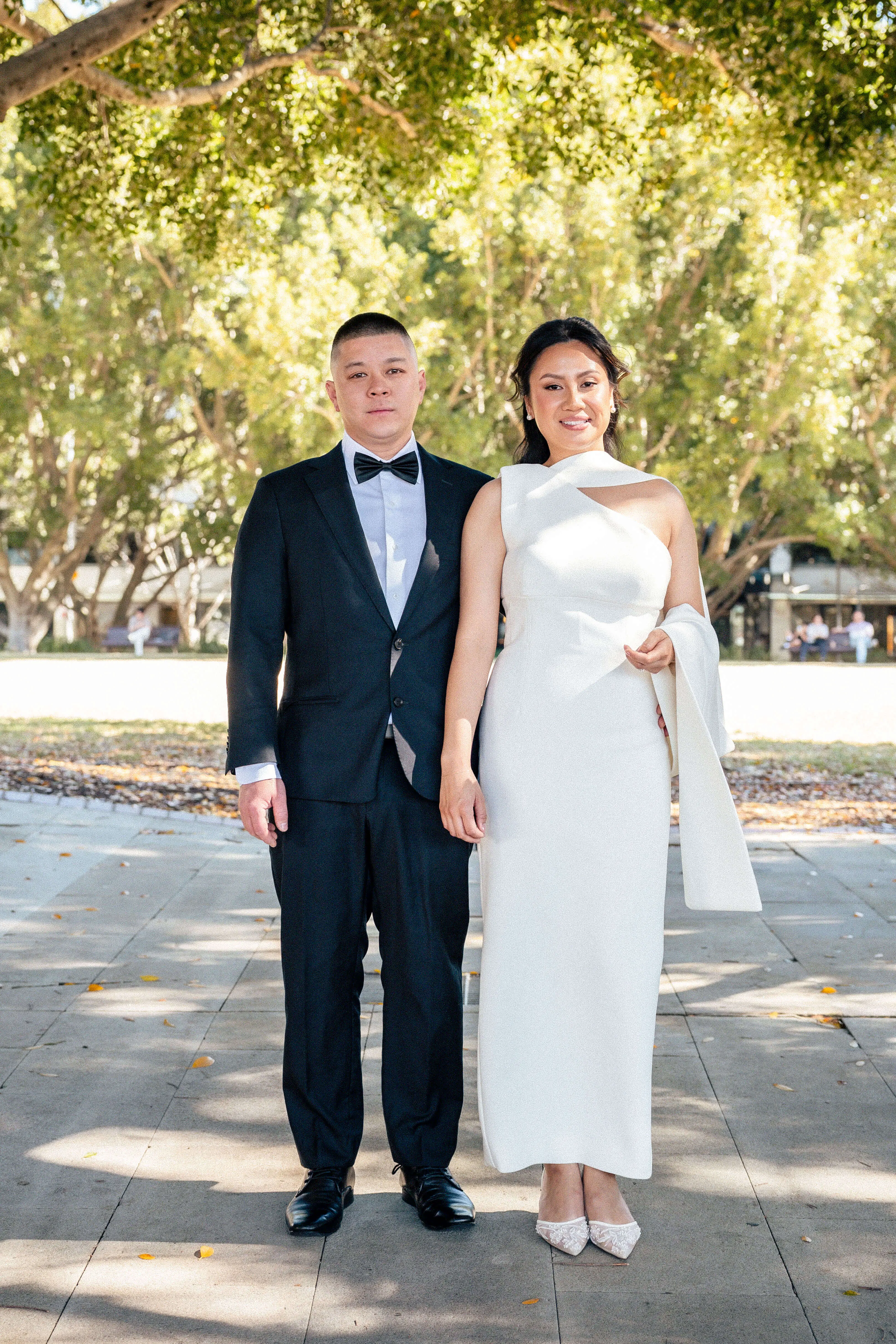 Formal portrait of the couple under soft daylight, framed by leafy park surroundings | EDG Studios