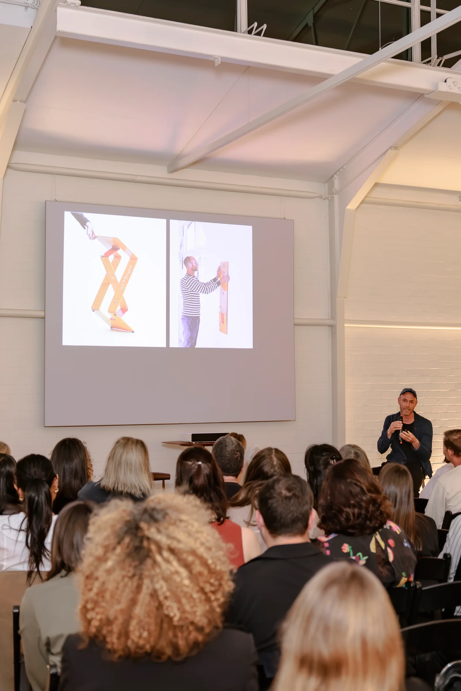 Audience watching a design presentation in the Alexandria showroom, photographed by EDG Studios.