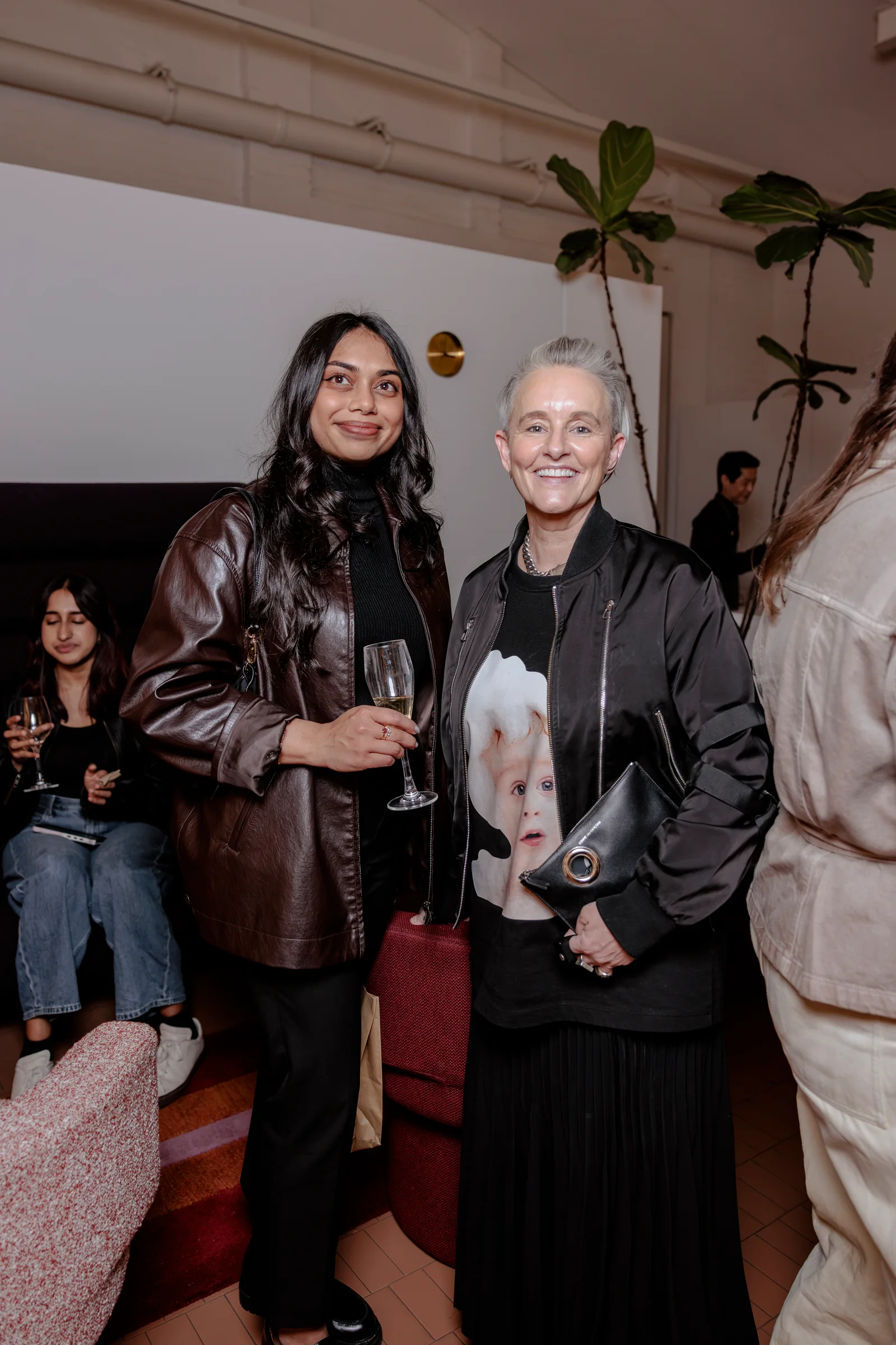 Two guests with drinks at the I'll Be Happy When reception, photographed by EDG Studios.