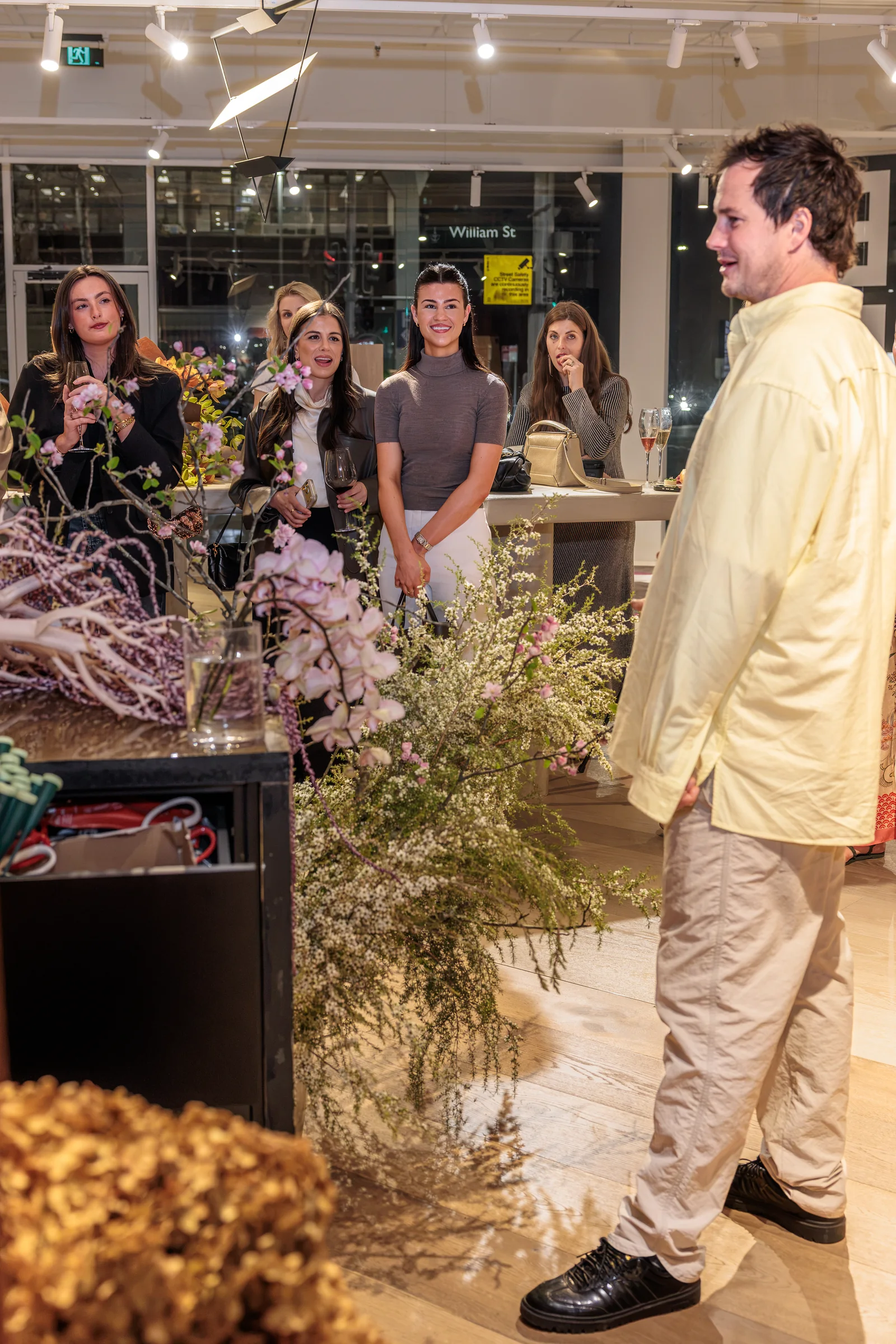 Florist demonstrating an arrangement to guests in the Made By Storey showroom, photographed by EDG Studios.