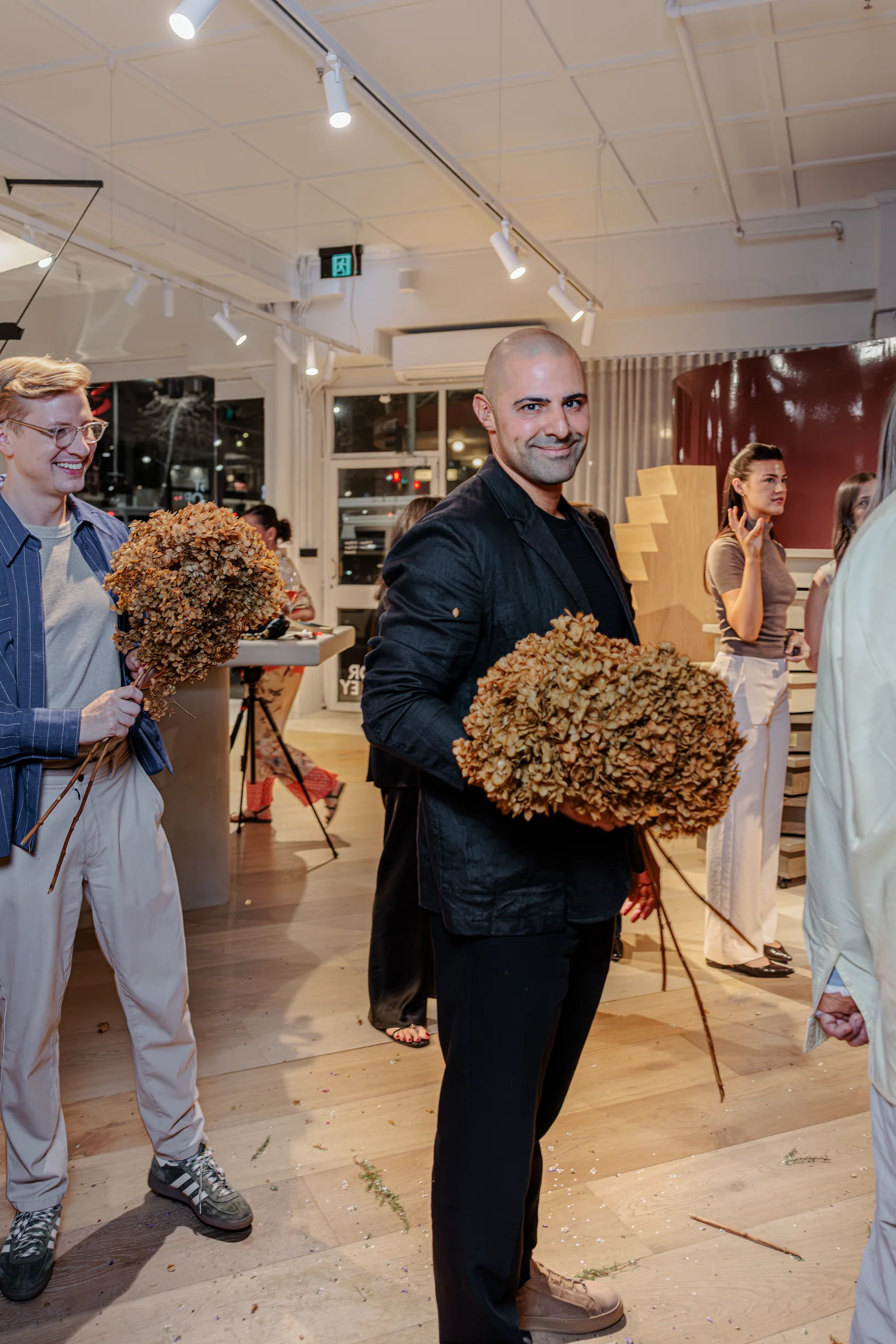 Guest holding dried hydrangeas during the showroom floral workshop, photographed by EDG Studios.