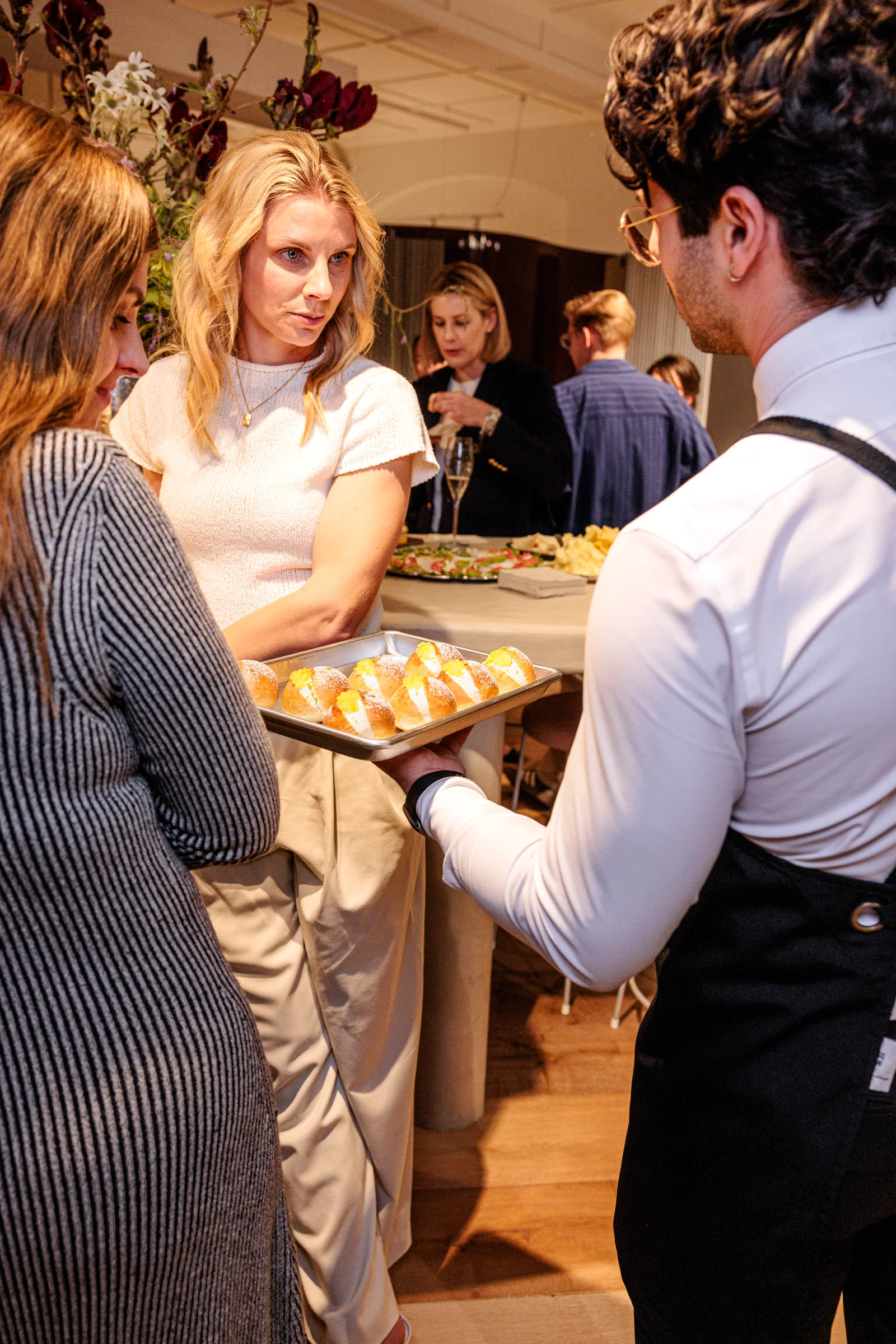 Guests chatting with a server carrying desserts at Made By Storey, photographed by EDG Studios.