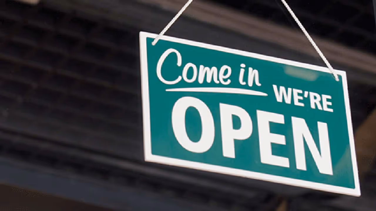 A photo of a "come in, we're open" sign
