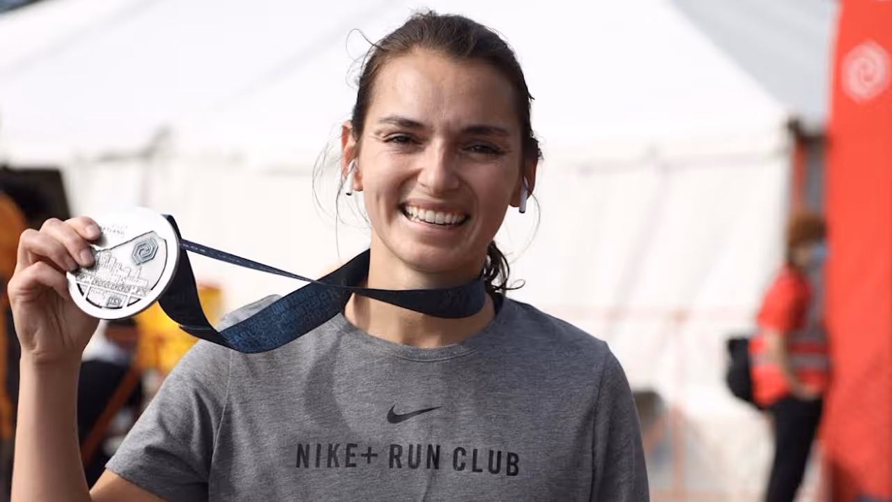An image of Briana Bri Barzola holding up a medal she was awarded for successfully participating in a sporting event