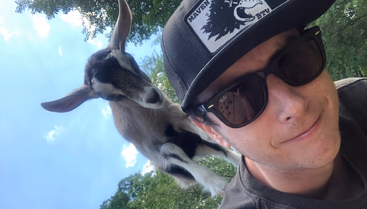 Michael Sheridan has a goat on his shoulders in this photo.