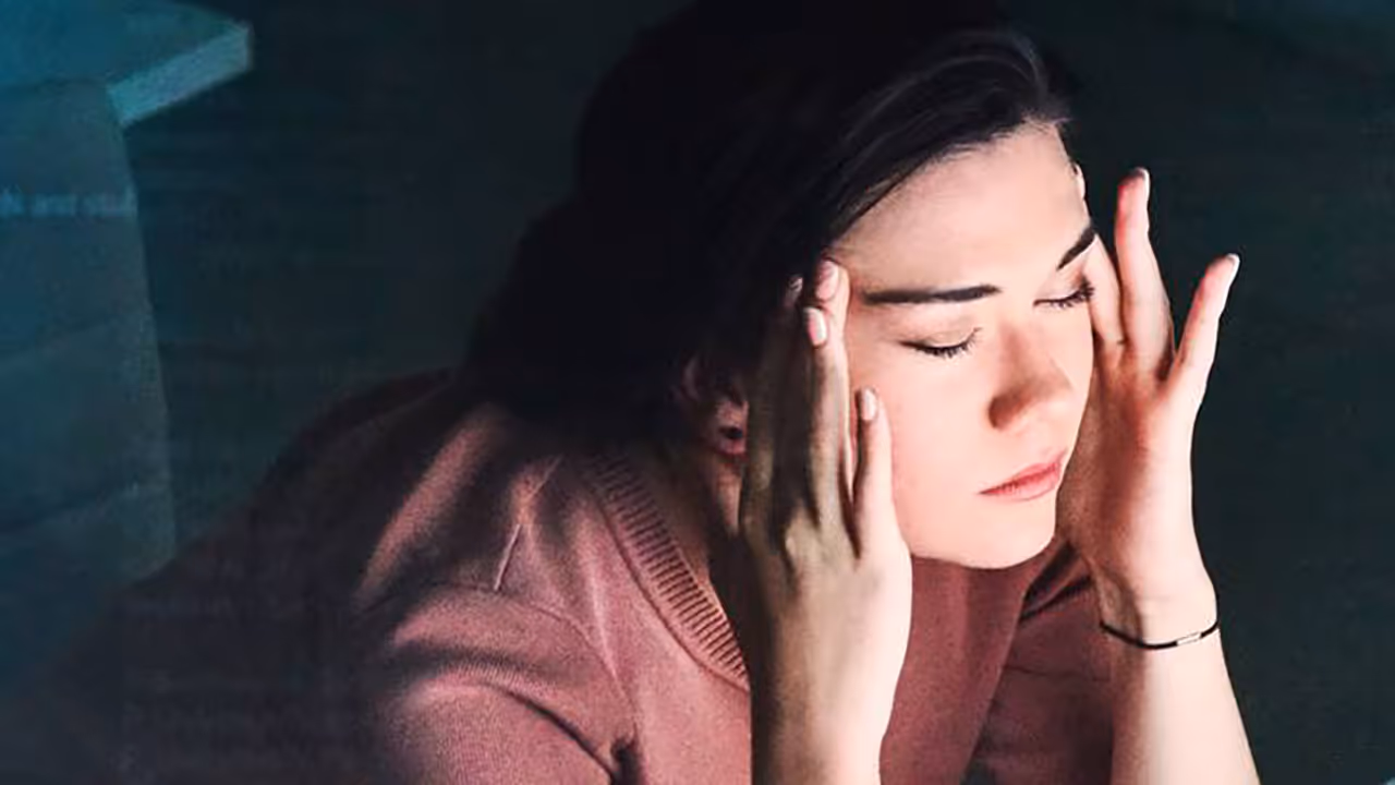 A person holding their head, who is stressed about the workload involved in their digital advertising job
