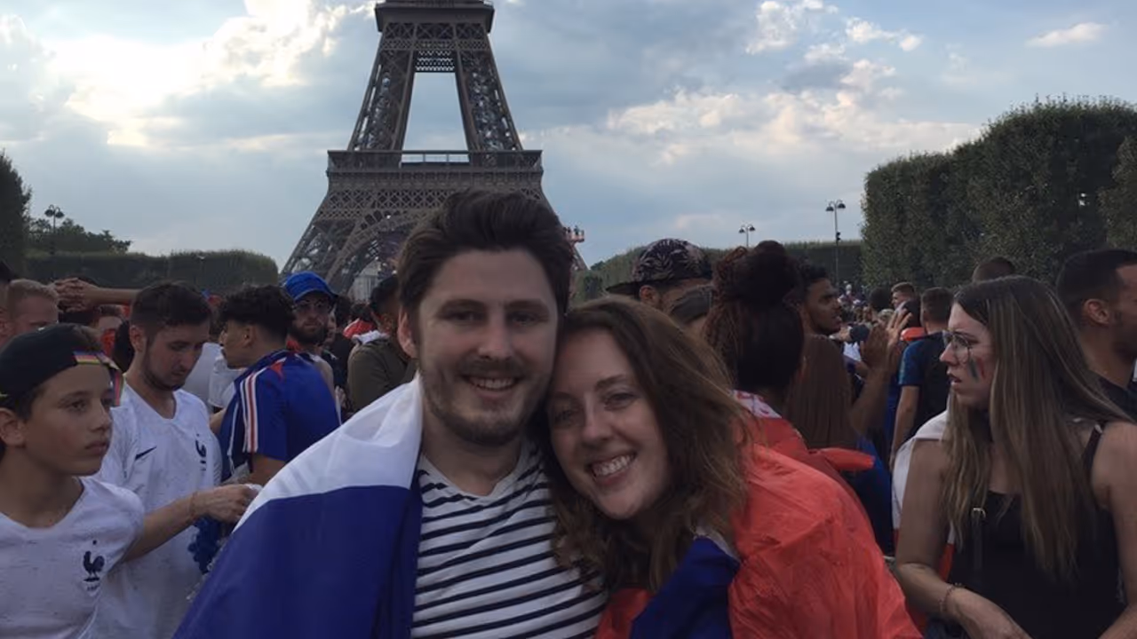 A photo of Baptiste and his wife in Paris, in front of a famous tower.