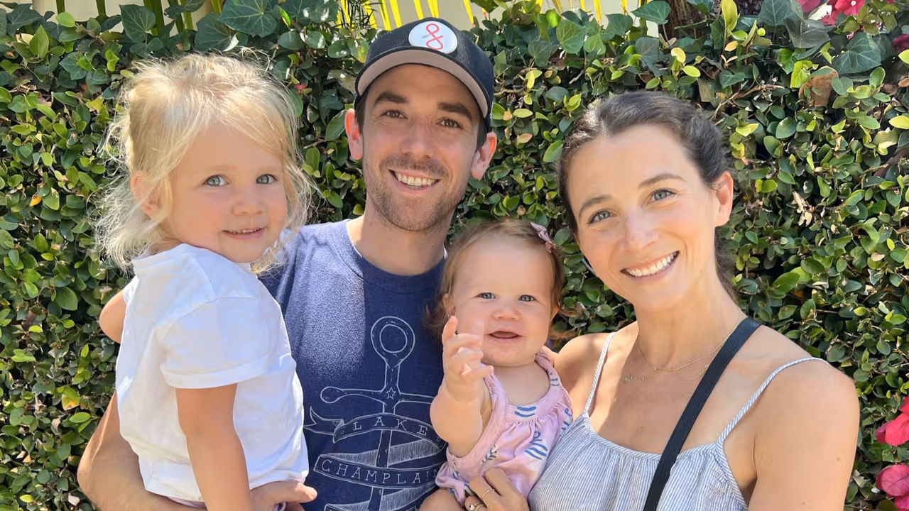 A photograph of Dillon, his wife, and children, taken outside. Dillon is wearing a hat.