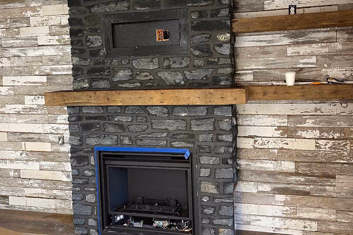 Black stone and brown wood fireplace