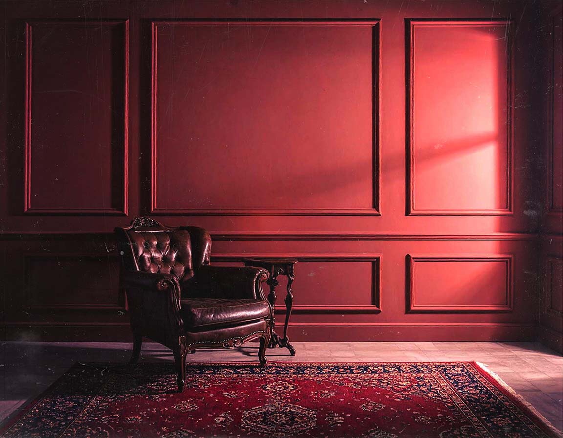 A dimly lit, elegant study with dark wood paneling and a leather chair.