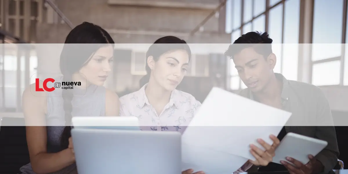 Two professionals examine a tablet displaying financial data.