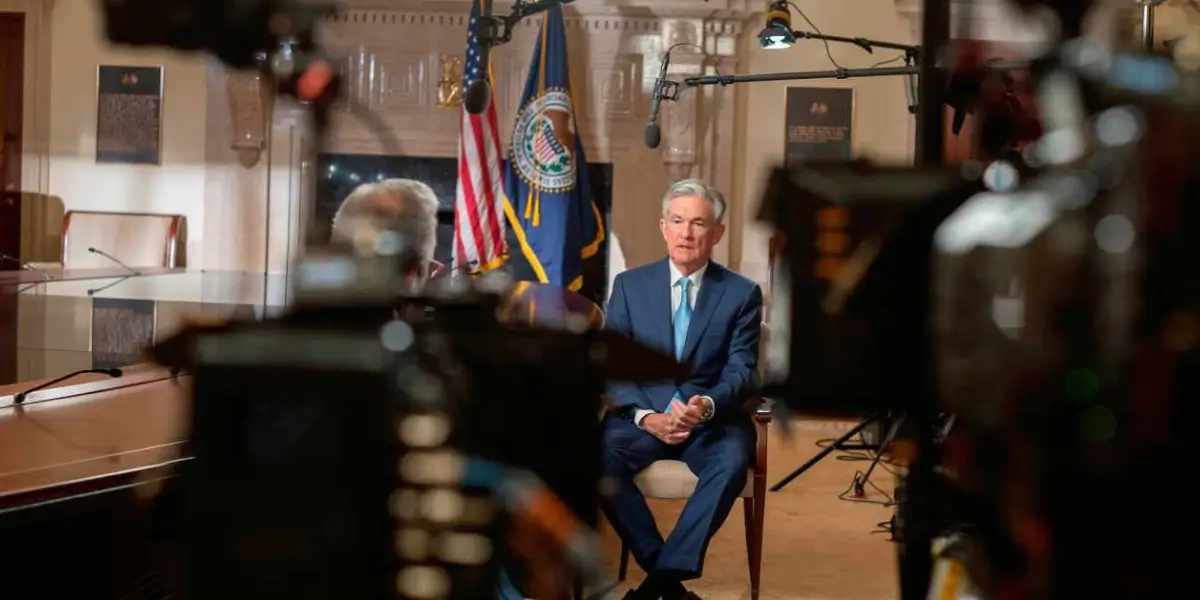 Jackson sits in a studio with a US flag and microphones.