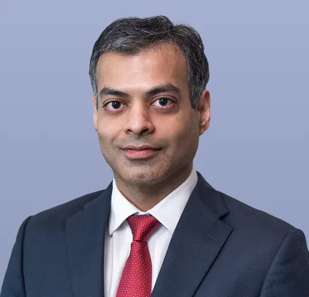 Ankit Agrawal, a man in a dark suit and red tie.