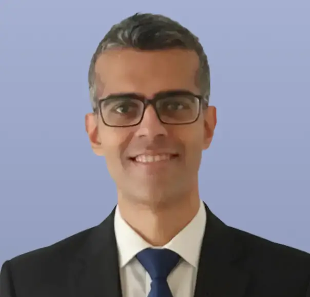 Ankit Shah, a man wearing glasses and a dark suit, smiling.