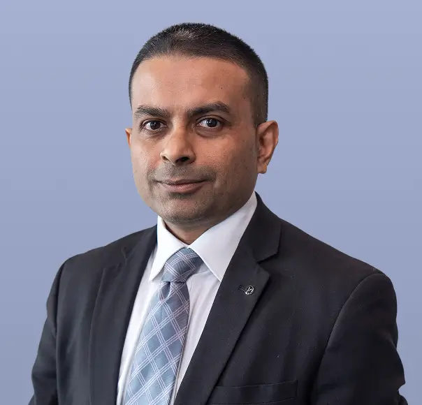 Pranob Gupta, a man in a dark suit and tie, is smiling.