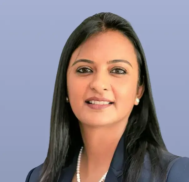 Charu Kunwar, a woman in a dark suit, smiles neutrally.