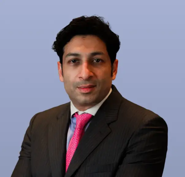 Vijay Bhatia, a man in a dark suit and pink tie.