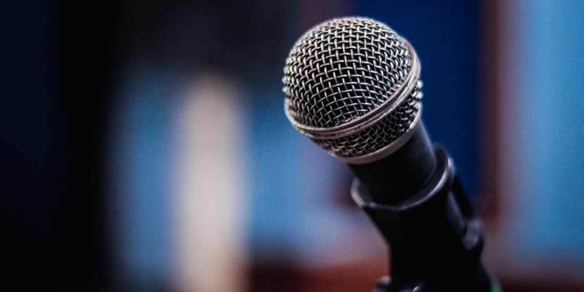 Black microphone in a blurred background.
