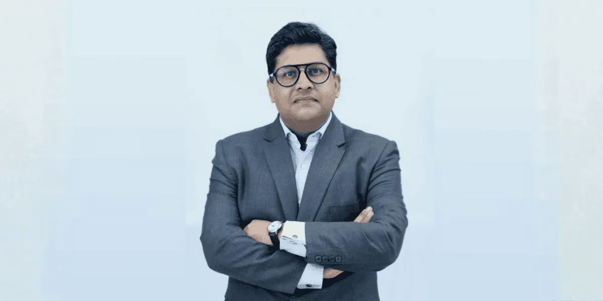 Rajesh, CEO of Lighthouse Canton, stands with arms crossed.