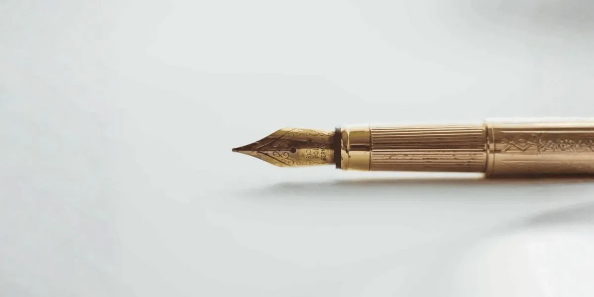 Gold fountain pen tip on white background.