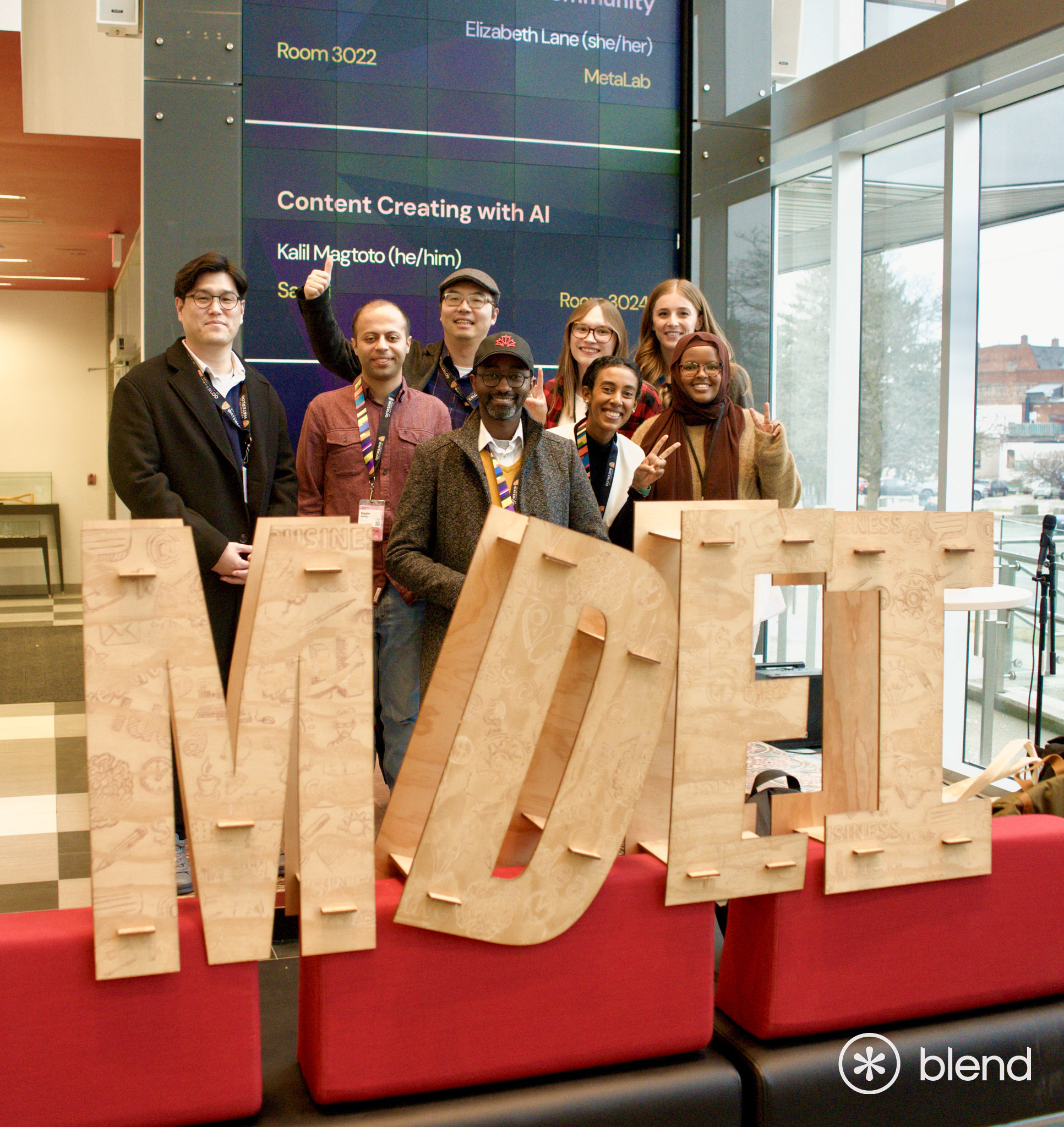 BLEND group photo in front of large wood letters "MDEI"