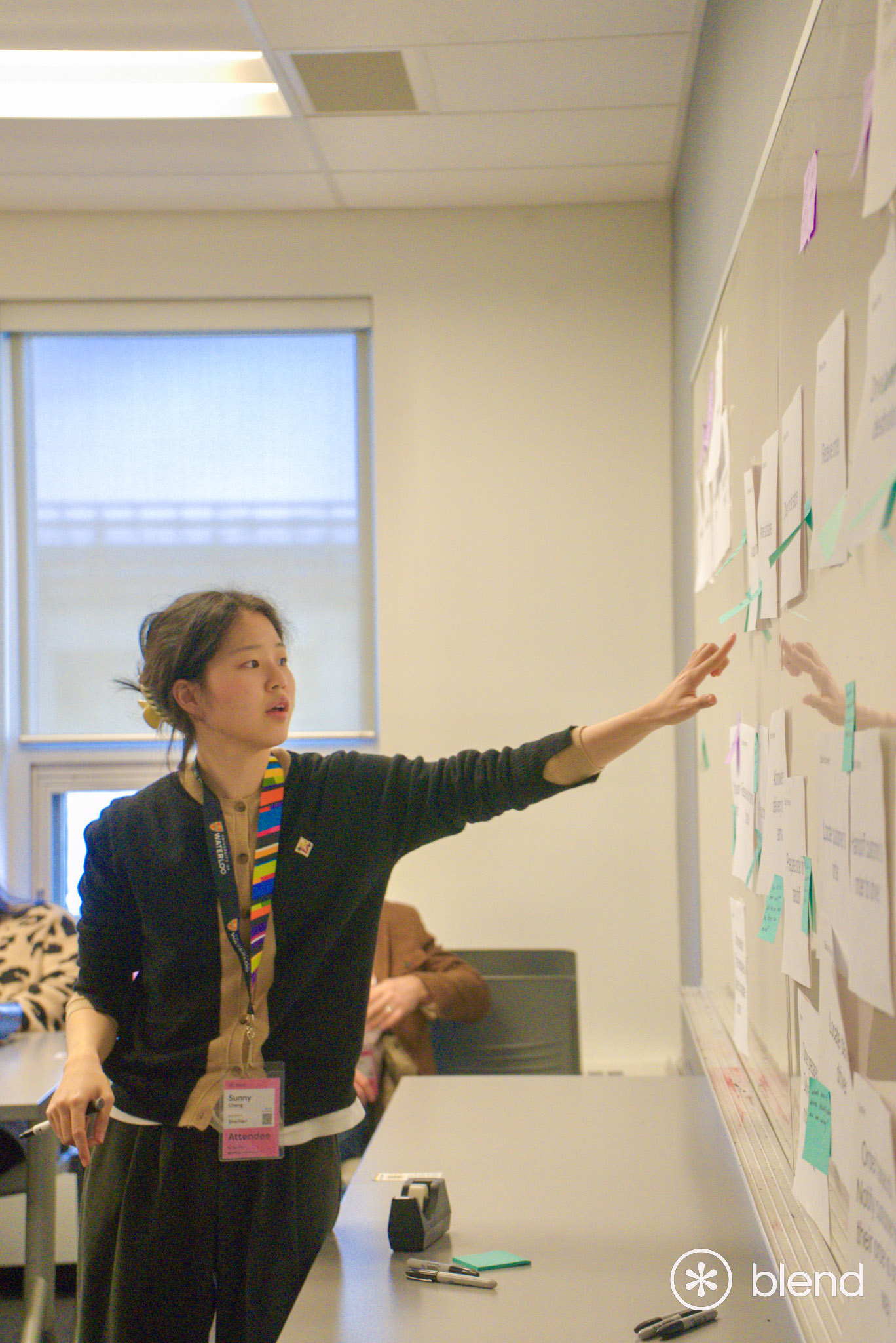 Side profile of person pointing to whiteboard