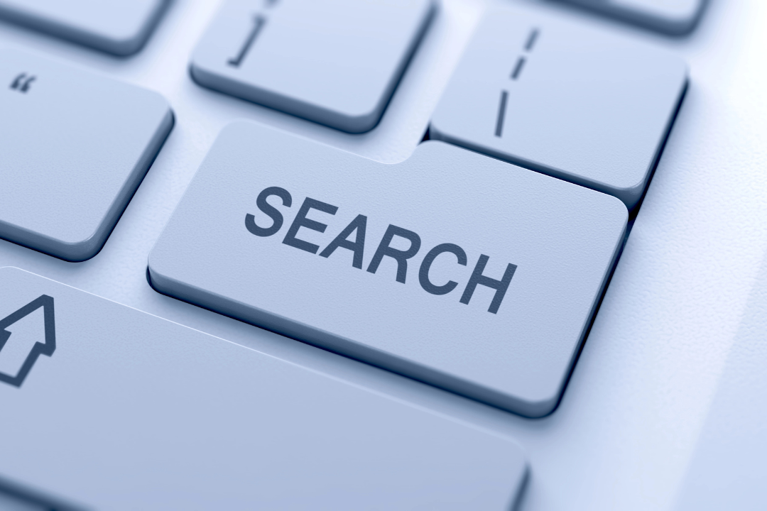 Close-up of a keyboard with a prominent "SEARCH" key highlighted, symbolizing internet search functions. The scene is minimalist and high-tech.