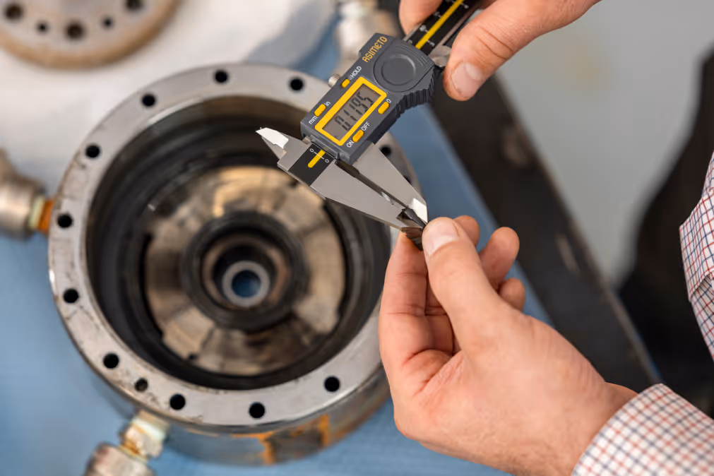 a close up of someone measuring a manufactured part