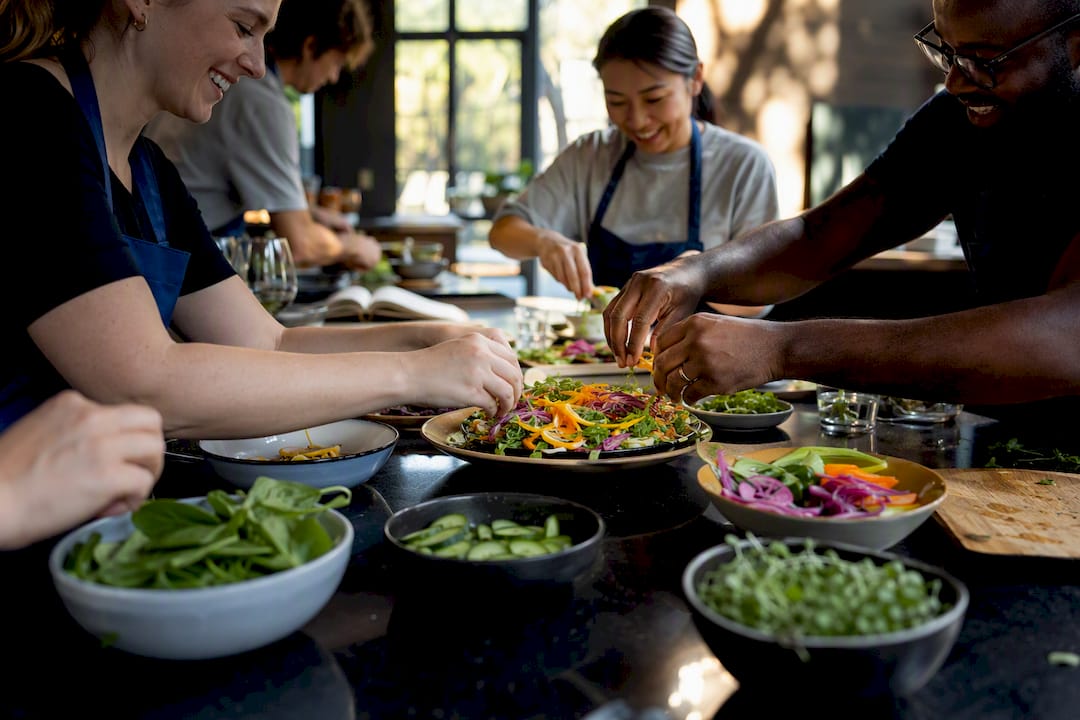 Hands plating food at team cooking event