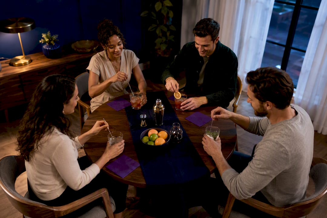 Friends mixing drinks while seated together