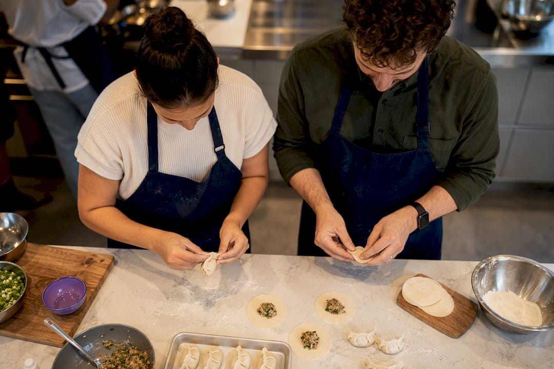 Couple folding dumplings in cooking class