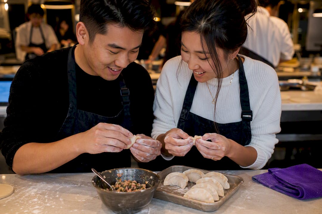 Couple folding dumplings during cooking class