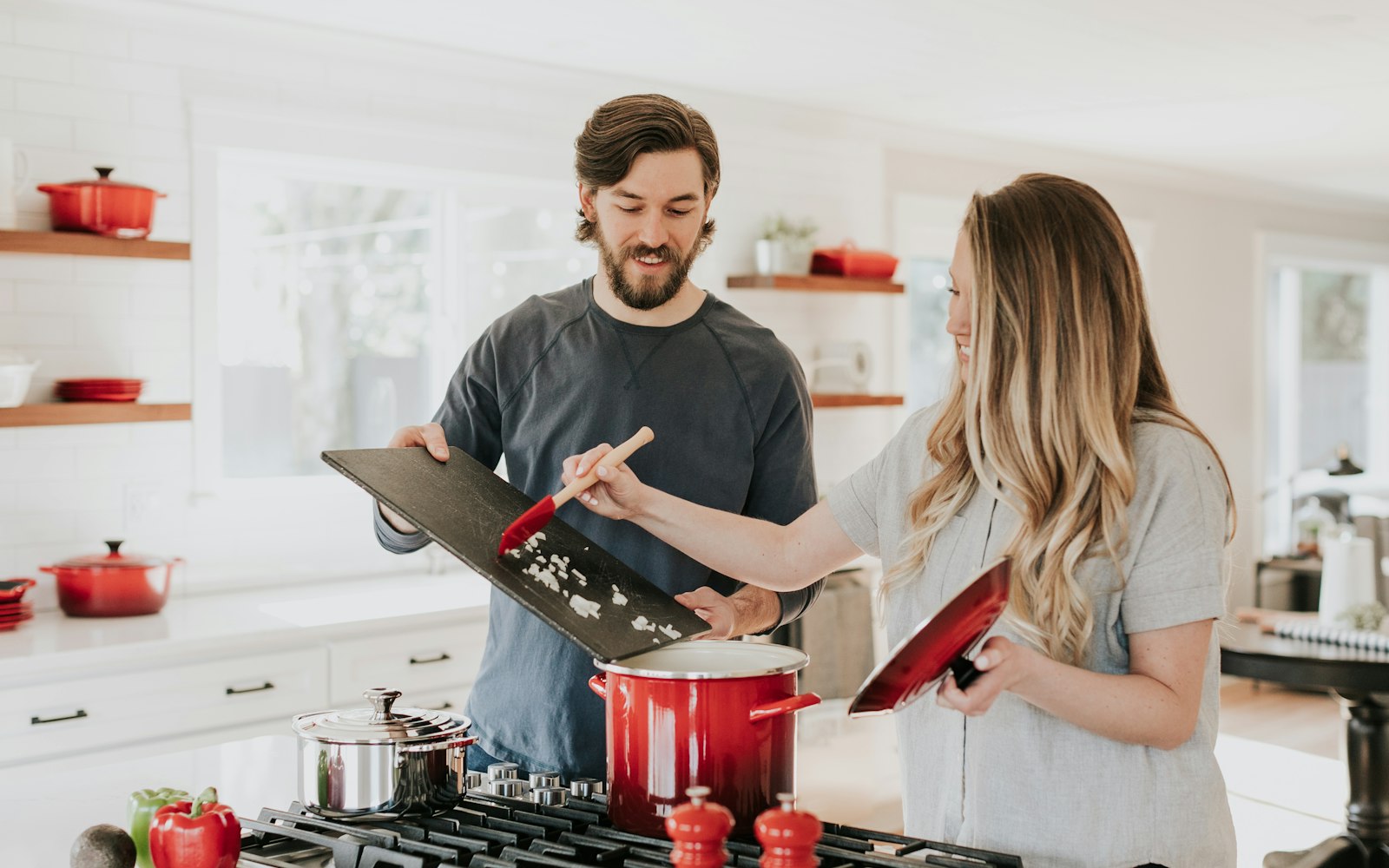 Couple cooking together in a bright kitchen during a cooking class near Marina del Rey