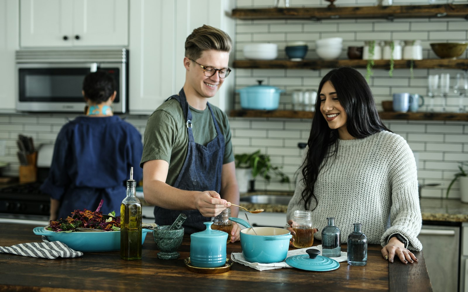 Group of friends cooking together at a kitchen island during a team cooking class near Playa Vista