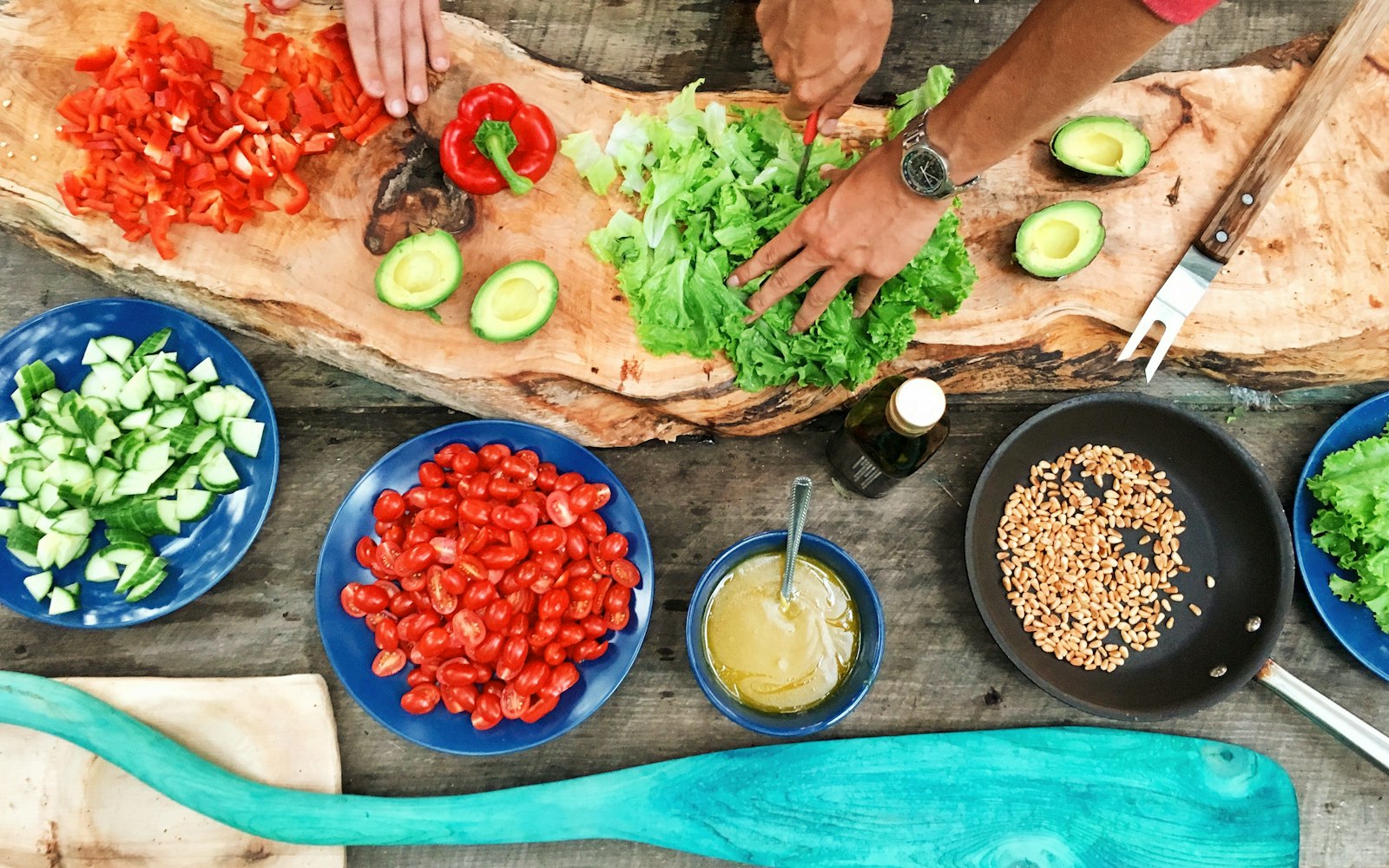 Hands chopping fresh vegetables on a wooden board during a cooking class near Mar Vista