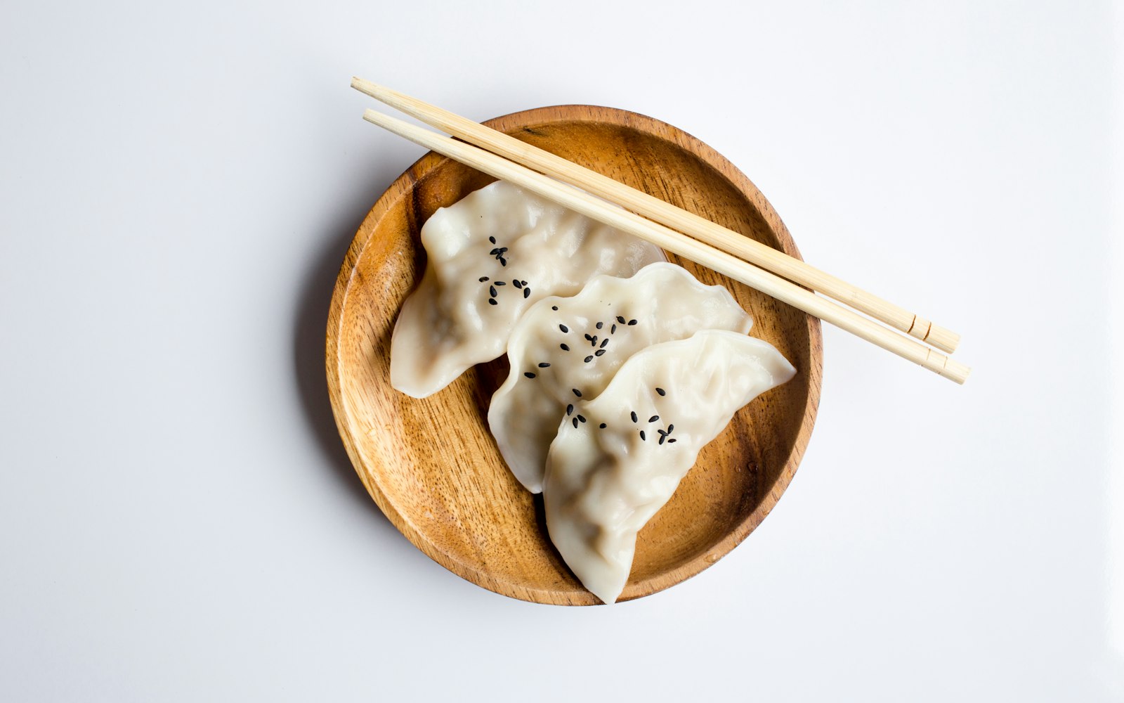 Wooden plate of handmade dumplings with chopsticks from a dumpling class near Westwood