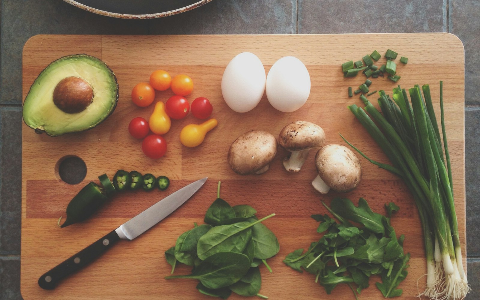 Fresh ingredients with avocado, eggs and greens on a cutting board for a cooking class near Westchester