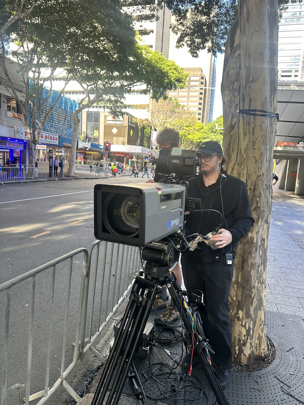 Camera operator filming the Royal Australian Navy March from the street