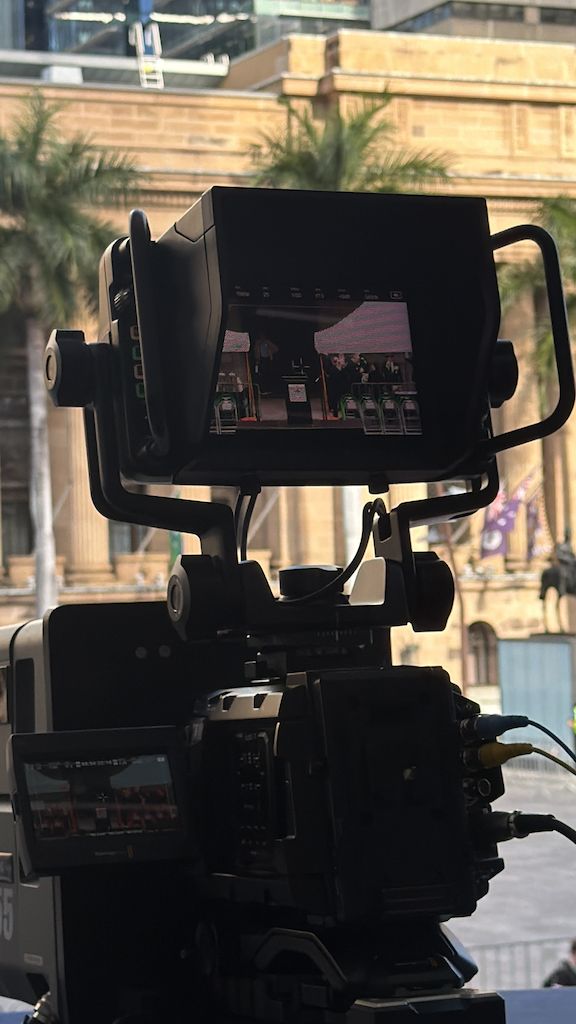 Camera viewfinder framing the Navy March in King George Square