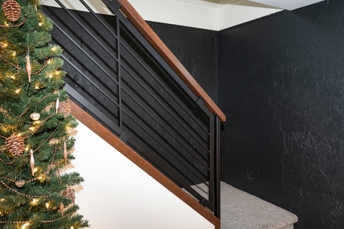 Detail of black stair railings heading down into a basement.