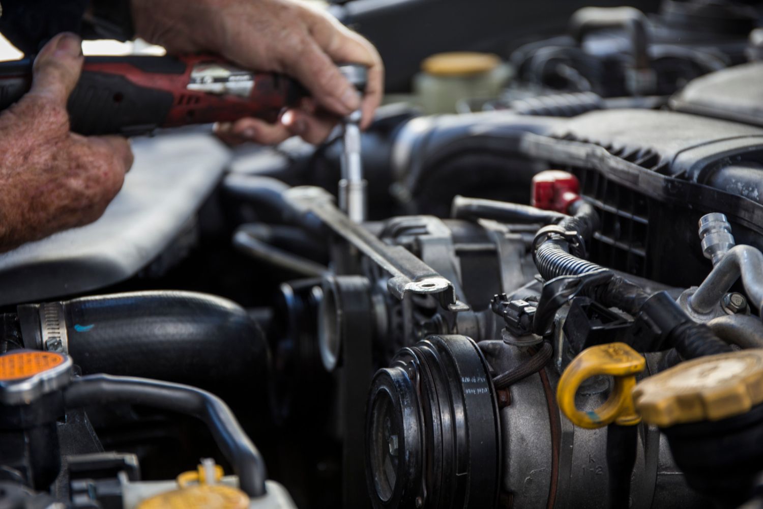 A close-up photo of a hand repairing a vehicle