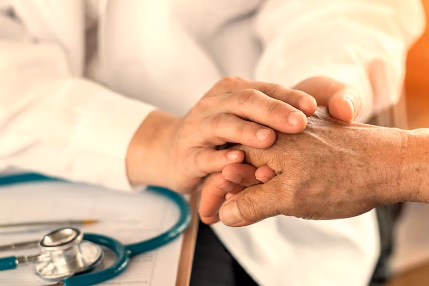 A doctor holding a patient's hand, representing clinical services at Sand Cherry Manor